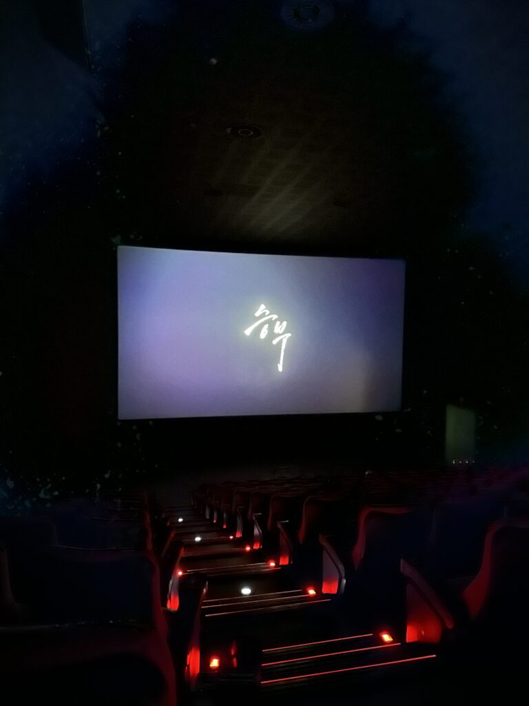 The title of the movie "The Game" (승부) displayed on a theater screen before the start of the 2025 film starring Lee Byung-hun.