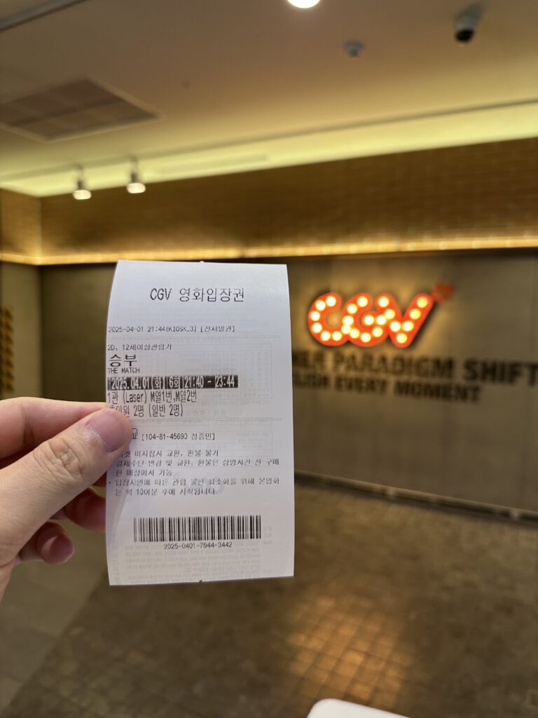 A movie ticket for "The Match" (2025) at CGV theater, showing the screening date as April 1, 2025, held in front of the CGV logo in the theater lobby.